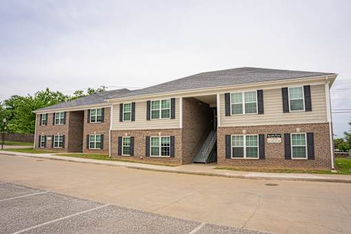 A two-story building with a parking lot in front.