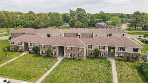 A large building with a brown roof and a green lawn in front.