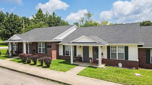 A house with a red brick wall and a grey roof.