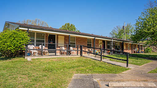 A house with a brown brick exterior and a covered patio area.