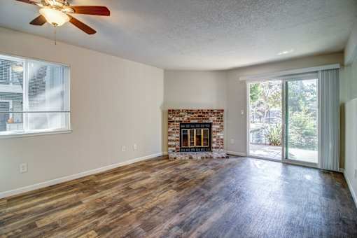 A room with a fireplace and sliding glass doors.