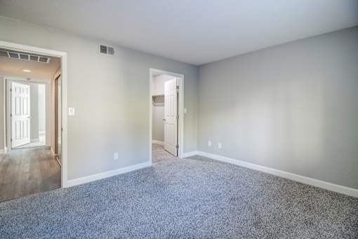 A room with a carpeted floor and a doorway leading to another room.