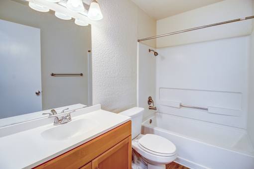 A white bathroom with a toilet, sink, and bathtub.