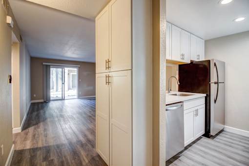 A kitchen with white cabinets and a refrigerator.