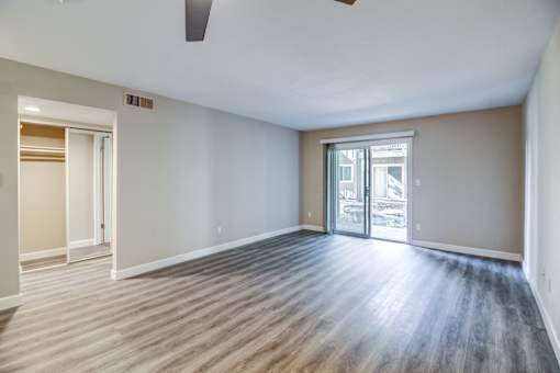A room with a wooden floor and a ceiling fan.