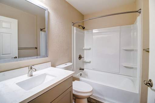 A bathroom with a sink, toilet, and bathtub.