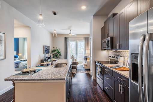 Gourmet kitchen with stainless steel appliances, subway tile backsplash, center island, and pendant lighting.