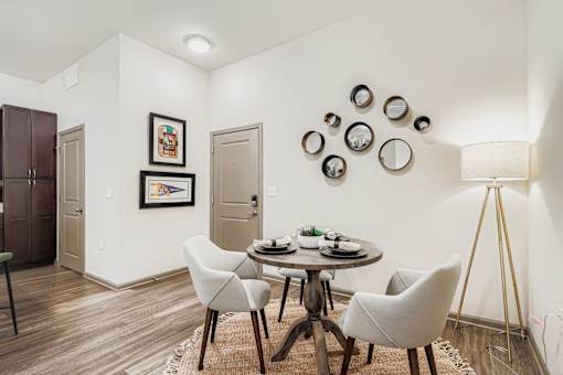 A dining room with a round table and chairs.