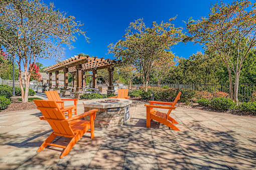 A patio with orange chairs and a gazebo.