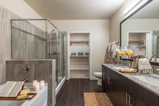 Modern bathroom with granite countertop, framed mirror, and dark wood vanity cabinetry.