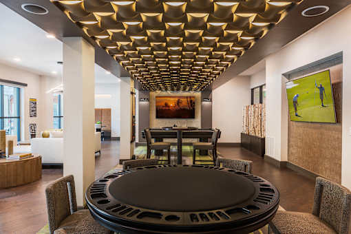 Spacious resident game room featuring a pool table, poker table, lounge seating, and entertainment amenities.