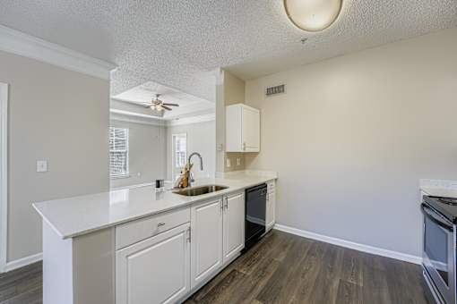 A kitchen with white cabinets and a white counter top.