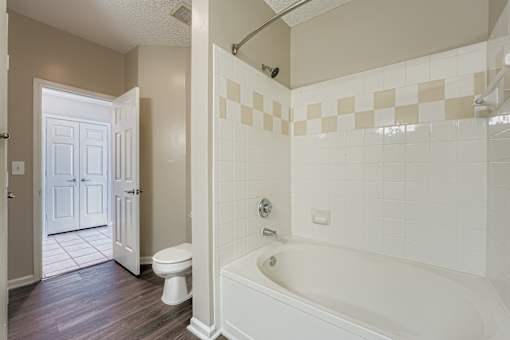 A white bathroom with a tub, toilet and sink.