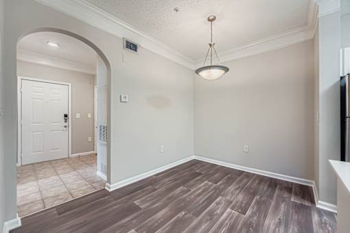A room with a white door and a light brown floor.
