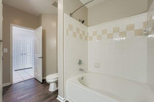 A white bathroom with a tub, toilet and sink.