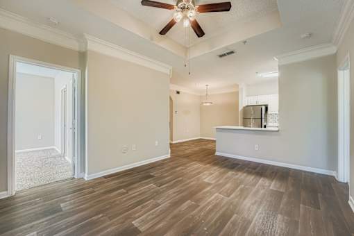 A room with a ceiling fan and wooden flooring.