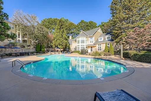 A large swimming pool in front of a house.