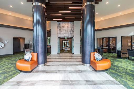 Luxury apartment resident lounge with stylish furnishings, natural light, and space for social gatherings.