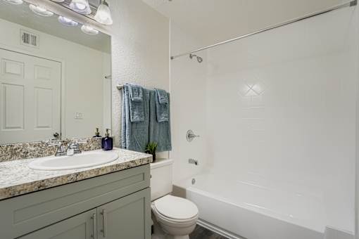 A bathroom with a toilet, sink, and shower.