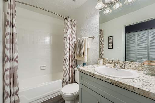A bathroom with a toilet, sink, and shower.