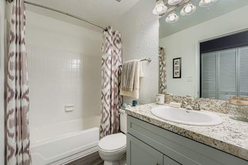 A bathroom with a toilet, sink, and shower.