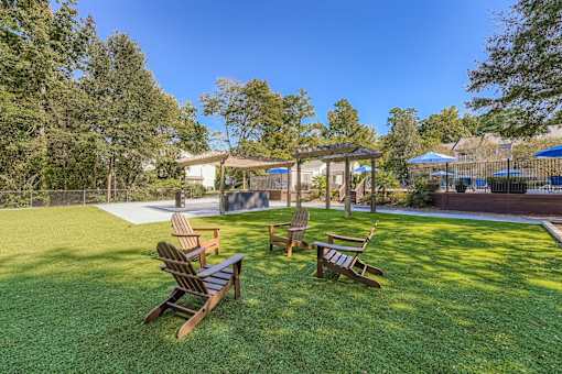 A backyard with a wooden bench and a gazebo.