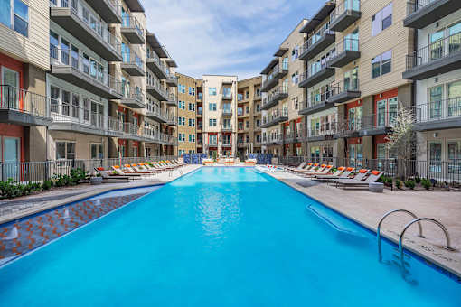 Resort-inspired pool area with clear water and surrounding lounge chairs.