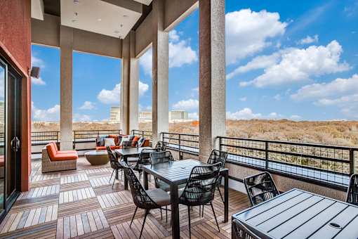 A patio with a table and chairs overlooking a desert landscape.