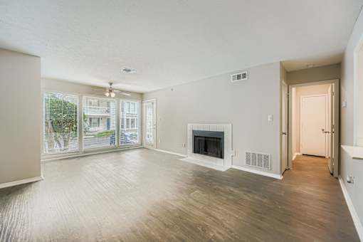 A spacious living room with a fireplace and sliding glass doors.