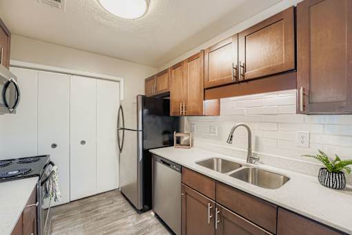 A kitchen with a black refrigerator and white cabinets.