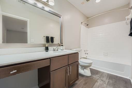 A white bathroom with a toilet, sink, and mirror.