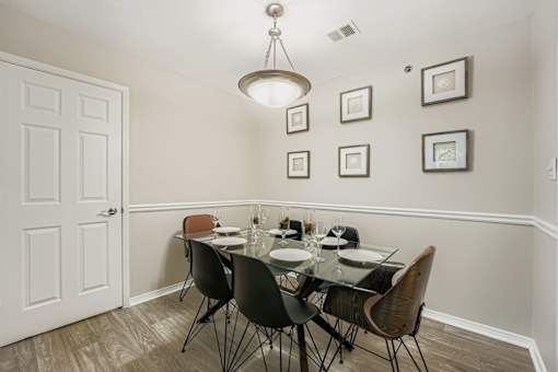 A dining room with a glass table and chairs.