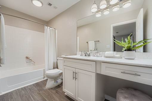 A white bathroom with a toilet, sink, and bathtub.