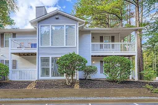 A house with a grey exterior and a balcony.