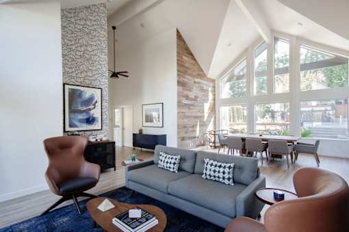 A living room with a grey couch and a brown chair.
