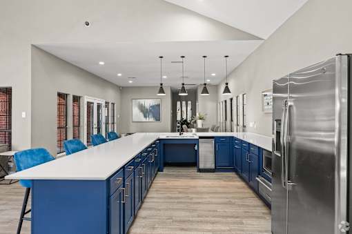 A modern kitchen with blue cabinets and a large island.