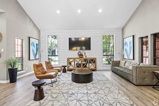 A living room with a brown chair, a brown coffee table, and a grey couch.