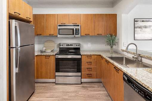 A modern kitchen with wooden cabinets and stainless steel appliances.