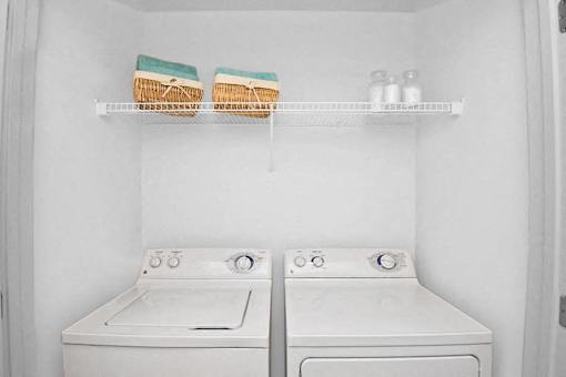 A white washing machine and dryer in a small laundry room.