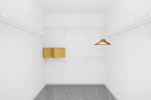 A room with a hanger and two yellow items on a shelf.