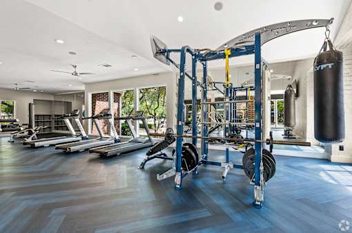 A gym with a variety of equipment including a punching bag.