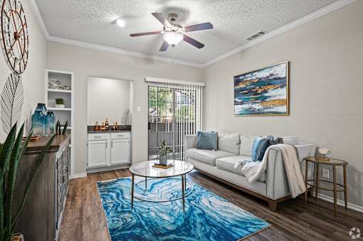 A living room with a white couch and a blue rug.