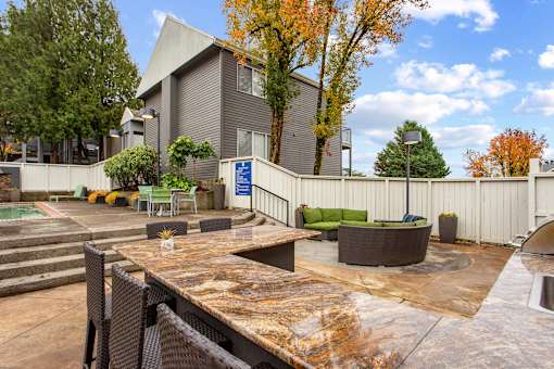 A patio area with a table and chairs in front of a building.