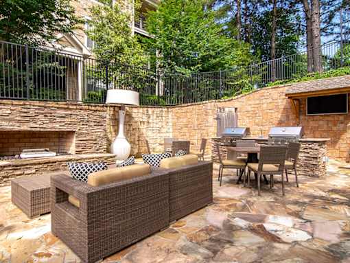 A patio with a couch, chairs, and a table.