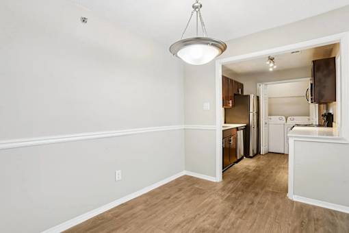 A kitchen area with a refrigerator, oven, and cabinets.