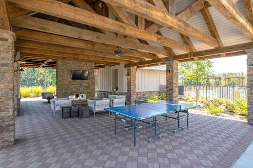A patio with a table and chairs and a TV on the wall.