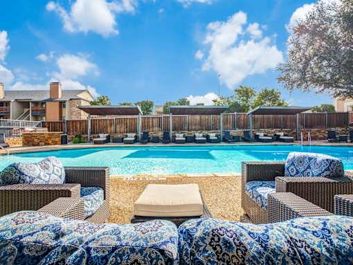A pool surrounded by chairs with a blue and white blanket.