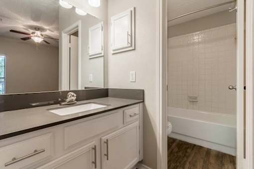 A bathroom with a white tub and a white sink.