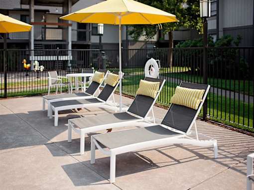 A set of outdoor furniture including chairs and a table is arranged on a patio.