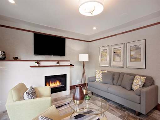 A living room with a fireplace, a couch, a chair, and a television.